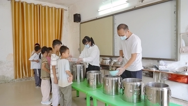 廖秋蘭、廖鋒林給學生分發營養餐。陸遠培攝
