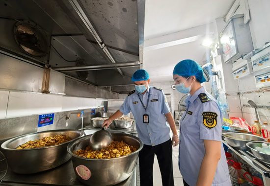 市場監管部門執法人員對一所學校食堂后廚進行檢查。何正君攝
