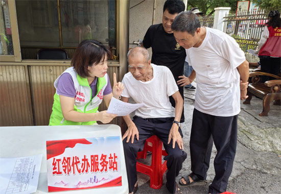 黃海路社區干部在紅鄰代辦服務站為群眾解答政策