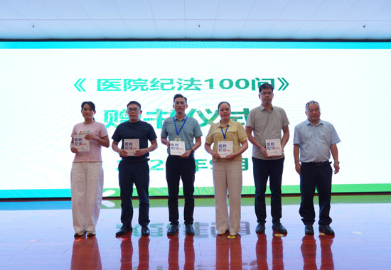梁世雄院長（右一）給各科室贈書《醫院紀法100問》。崇左市人民醫院供圖
