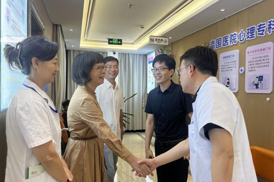 【图片1：蔡篮理事长（左二）与南宁南国医院心理科芦智刚主任亲切握手交流。摄影：林雨晴】