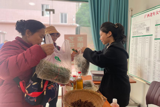 閆如玉（右一）到廣西老年大學擺攤推介銷售西秀村特色農產品。駐村工作隊供圖