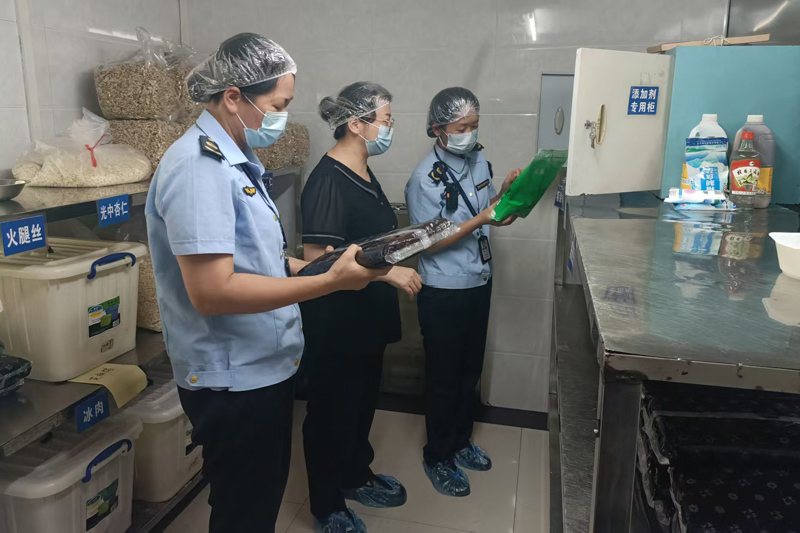 執法人員到月餅小作坊檢查食品添加劑使用情況。