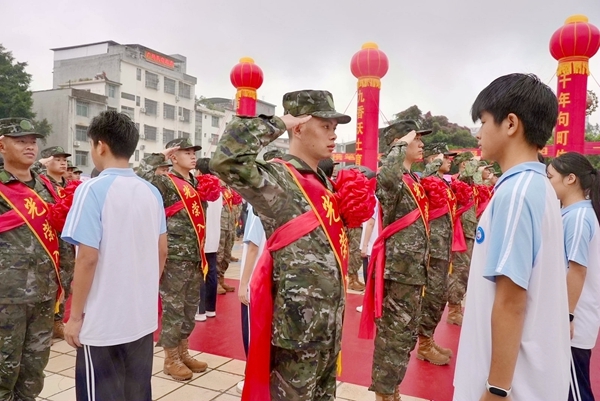 西林县民族高级中学学生代表现场为入伍新兵披绶戴花。陆宗林摄