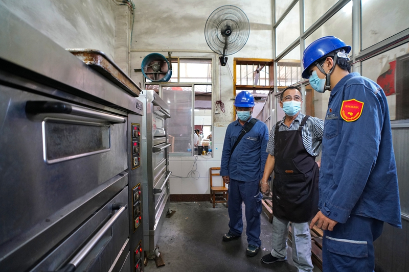 柳州柳城供電局工作人員了解月餅加工廠生產用電情況。蒙玉彬攝