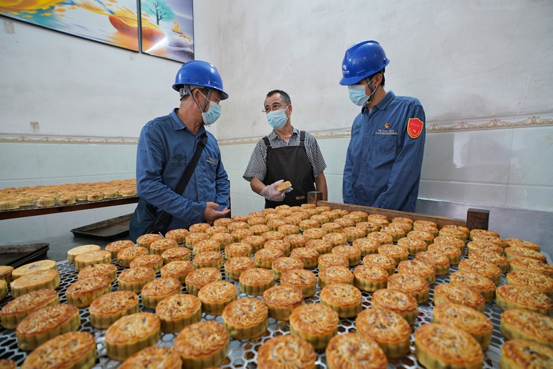 馨園餅廠負責人為柳州柳城供電局工作人員介紹月餅生產加工情況。蒙玉彬攝