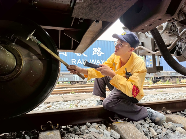 檢車員唐雷正在對車輛走行部進行技術檢查。余塑攝