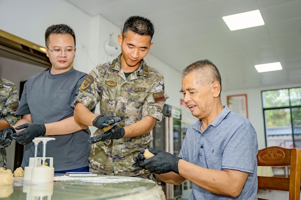 武警官兵與老兵一同制作月餅。王宏侶攝