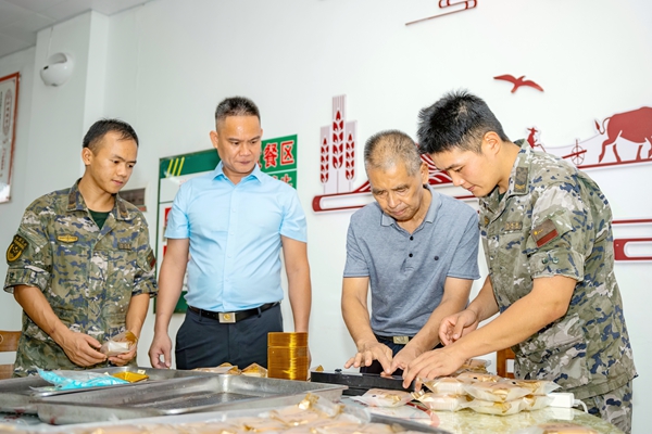 武警官兵與老兵一同包裝月餅。王宏侶攝