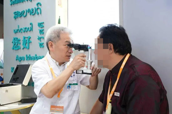 温利辉（左）医生正在为求医者做检查。中南大学湘雅二医院桂林医院供图