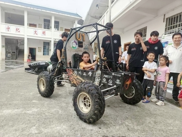 柳州工学院LS Racing车队将赛车开进滚良村，当地小学生体验巴哈大赛赛车。