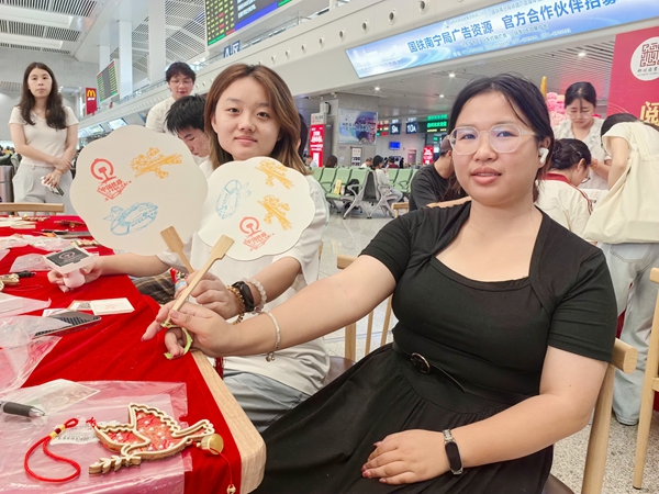 旅客們在扇子上蓋印柳州站專屬打卡章作為旅途紀念。戴雨婷攝