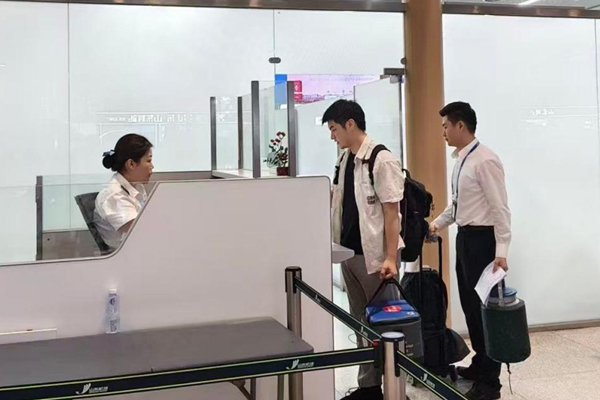 北部灣航空地面保障經理王振宇引導攜帶造血干細胞旅客快速過檢。湯子垚攝