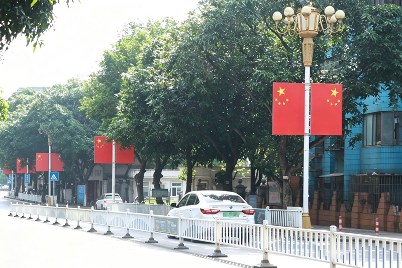 道路两旁悬挂着国旗。韦新娜摄