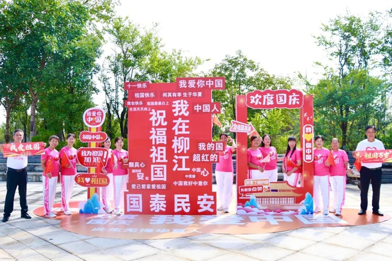 市民在国庆主题展板前合影。韦新娜摄