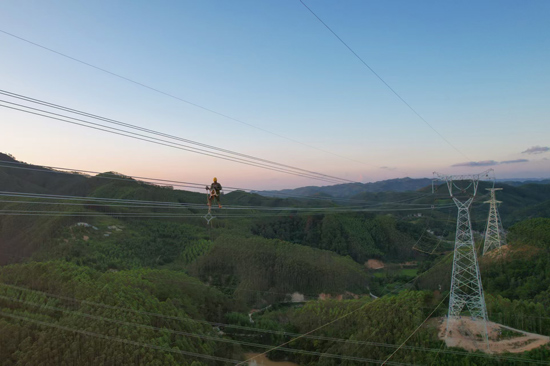 电力工人在500千伏布山输变电工程（标段二）久隆～布山500千伏线路开展高空作业。蒙伟琪摄