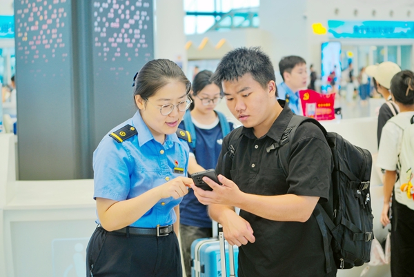 图为南宁东站客运值班员解答学生旅客问询。肖锐摄