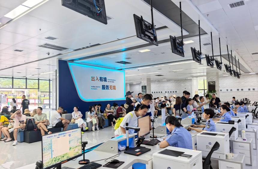 国庆假期，在中越德天（板约）瀑布跨境旅游合作区出入境办证大厅内，民警为群众办理证件。
