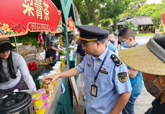 执法人员对食品摊位开展检查。何正君摄