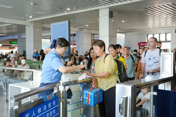 桂林北站工作人員為旅客辦理車票核驗手續。鄭長賢攝