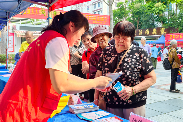 工作人员向老年群众普及相关政策知识。
