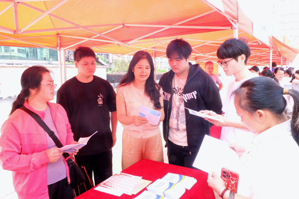 工作人員向求職者介紹高校畢業生就業政策。蔣家紅攝