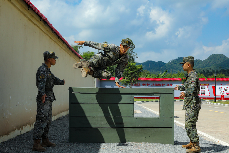 武警官兵飛躍矮牆。代禮意攝